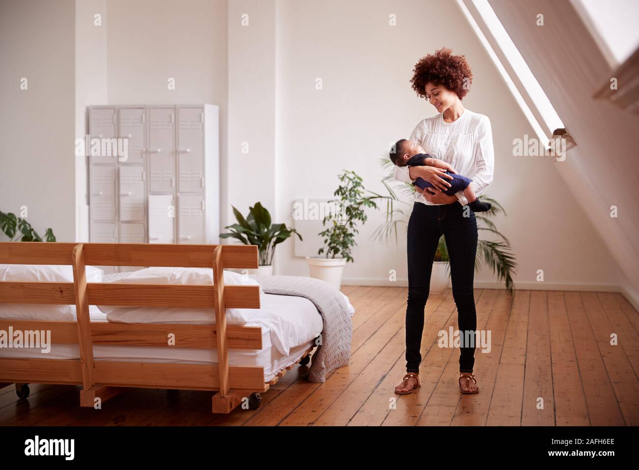 Liebevolle Mutter, neugeborenes Baby zu Hause in Loft Apartment Stockfoto