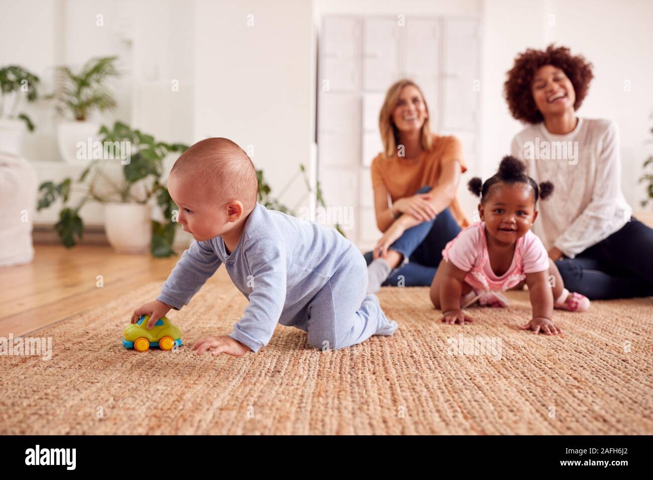 Zwei Mütter treffen für Spielen mit Babys zu Hause in Loft Apartment Stockfoto