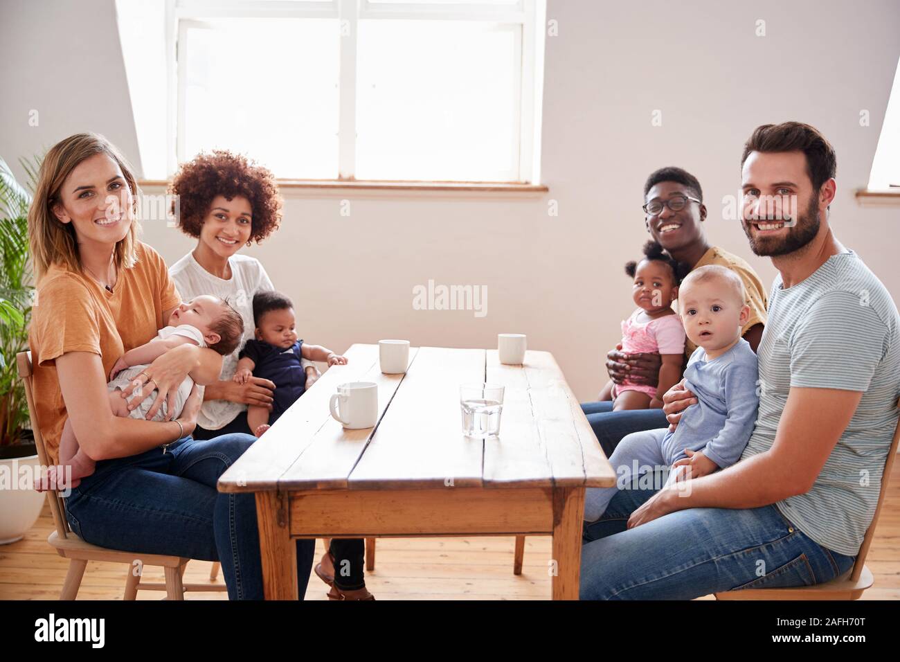 Porträt von zwei Familien mit Babys Treffen um Tabelle auf Play Datum zu Hause Stockfoto