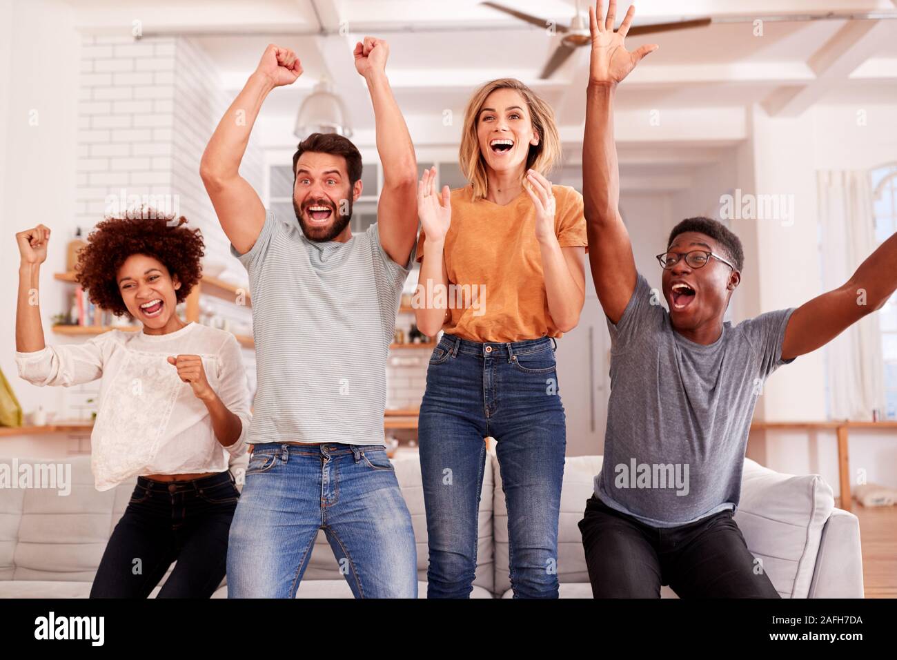 Aufgeregt Gruppe von Freunden Sitzen auf einem Sofa Sport im Fernsehen und zu feiern. Stockfoto