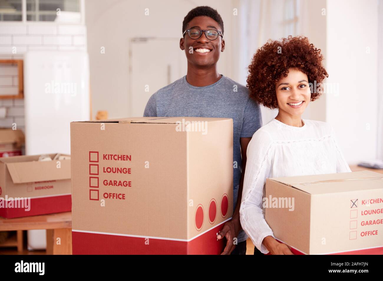 Portrait von lächelnden Paar Kisten in die neue Heimat am Umzugstag Stockfoto