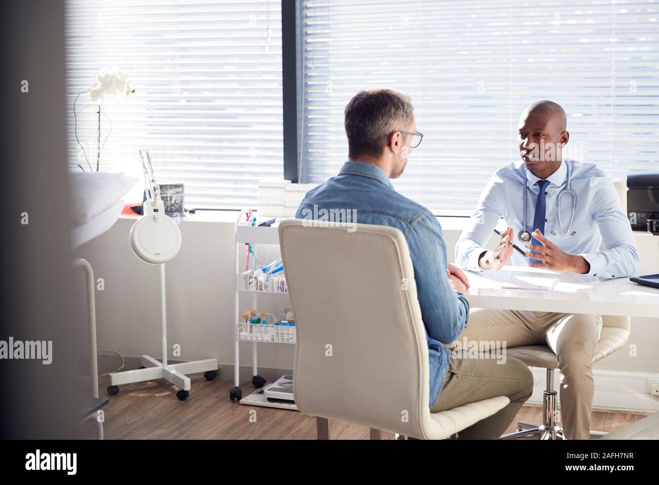 Reife männliche Patient in Absprache mit dem Arzt im Büro Stockfoto