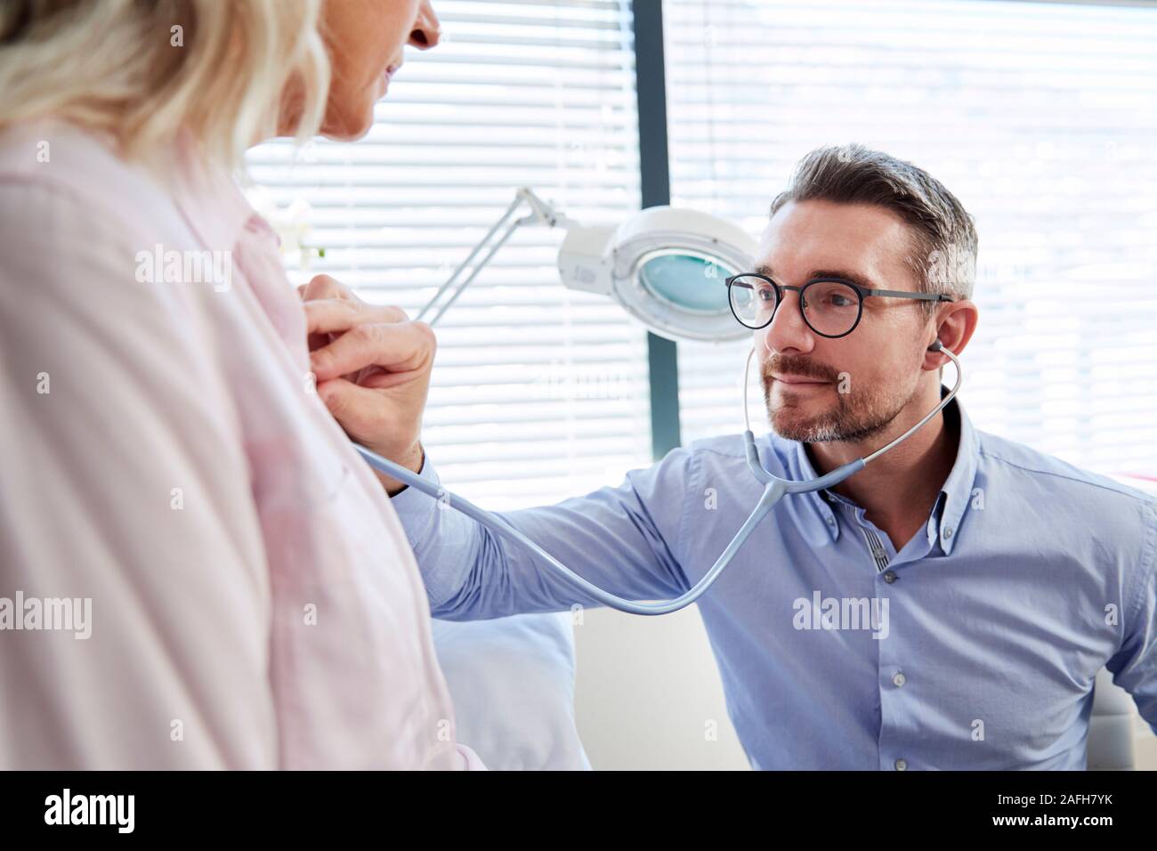 Reife weibliche Patienten in medizinische Untersuchung mit Arzt im Büro Stockfoto