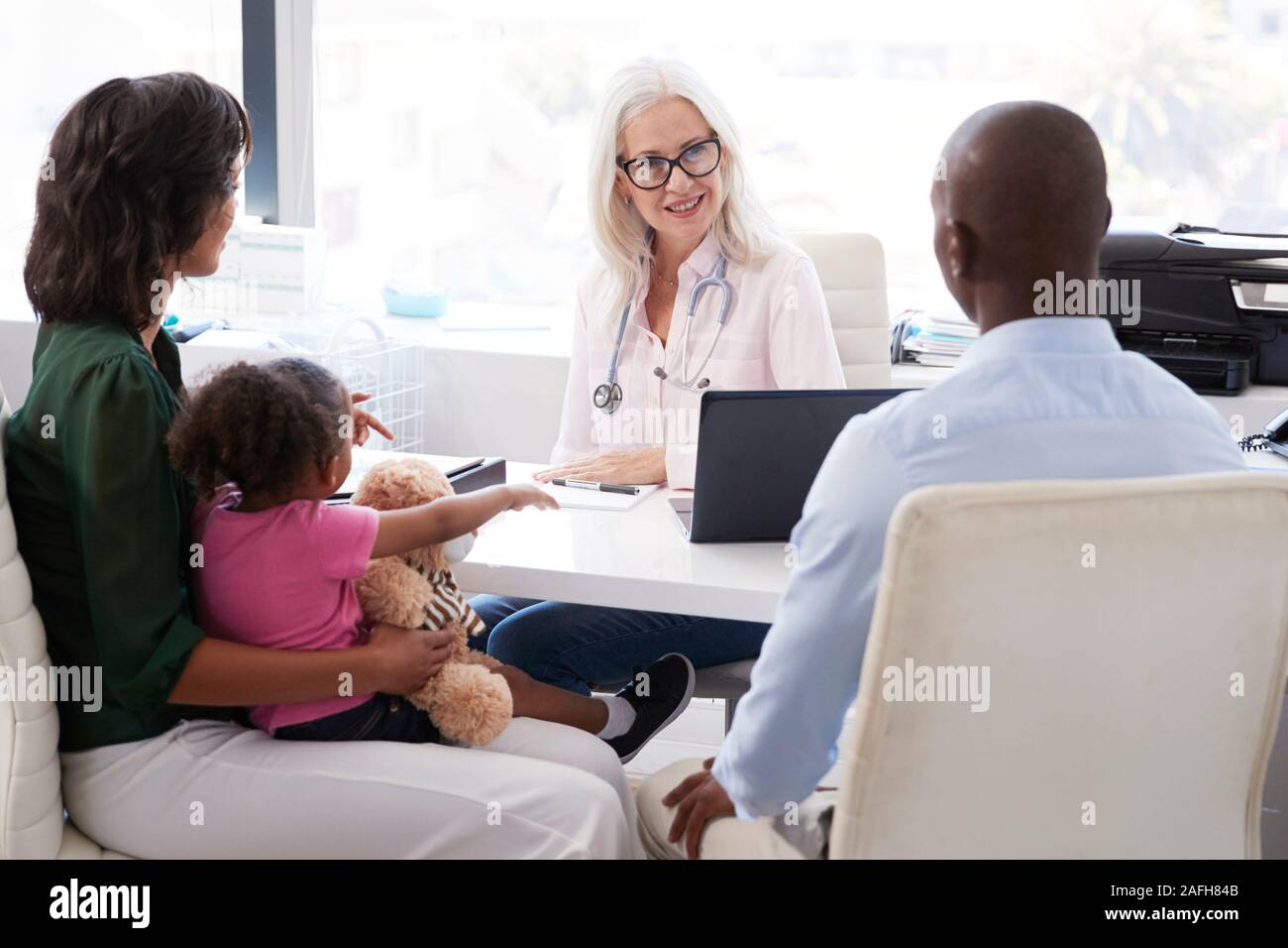 Familie mit Tochter in Absprache mit Arzt im Büro Stockfoto