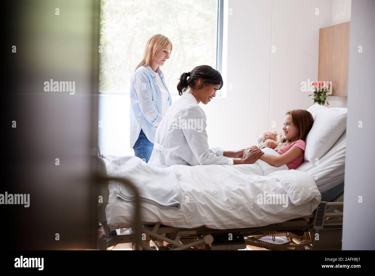 Ärztin, Mutter und Tochter im Bett im Krankenhaus Stockfoto