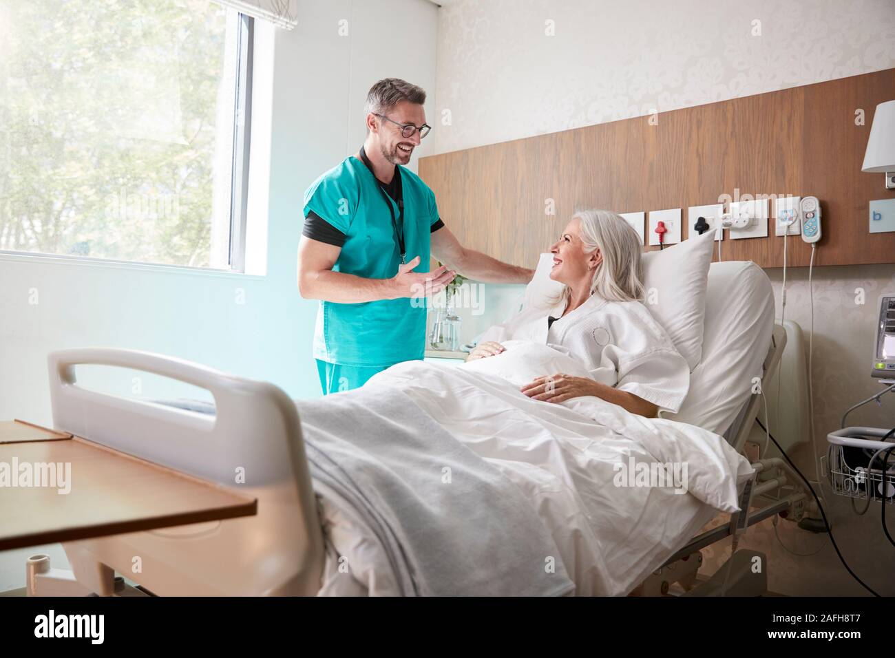Chirurg besuchen und das Gespräch mit Reife Weibliche Patienten im Krankenhaus Bed Stockfoto
