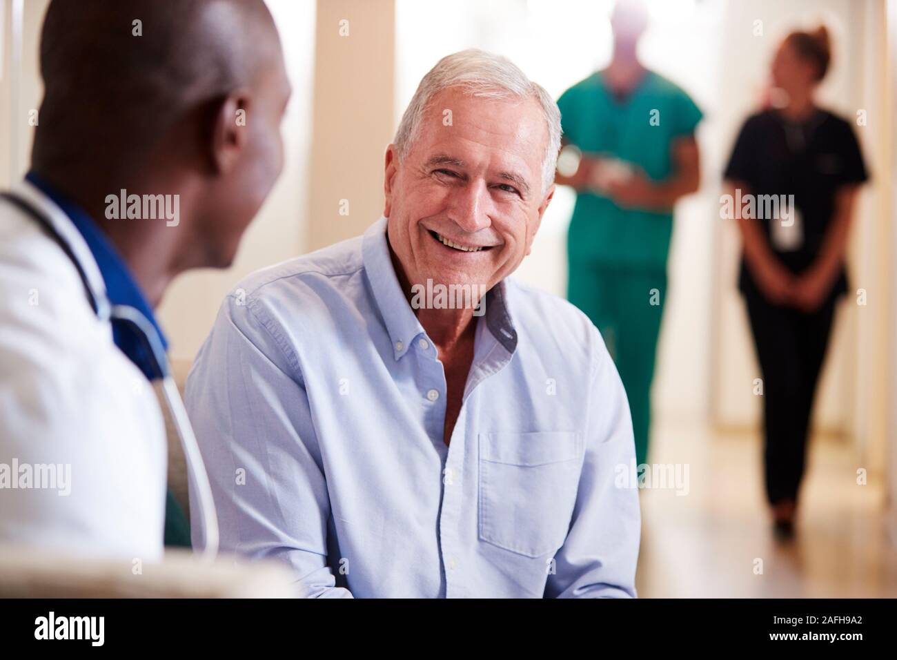 Arzt begrüßen zu älteren männlichen Patienten im Krankenhaus Stockfoto