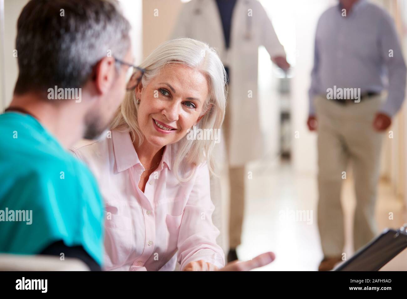 Arzt begrüßen zu älteren weiblichen Patienten, im Krankenhaus Stockfoto