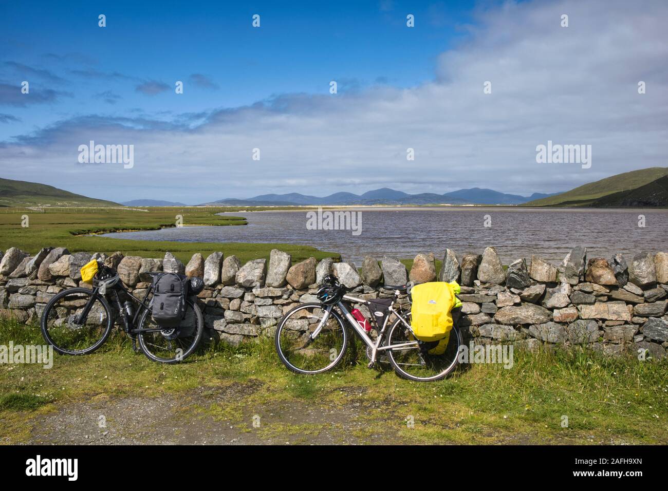 Touring Bikes mit Panniers, die sich am Atlantik, Northton, Insel Harris, Outer Hebrides, Schottland, an die Trockensteinmauer lehnen Stockfoto