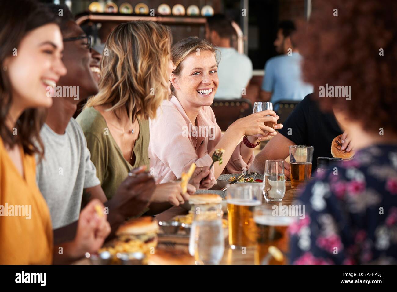 Gruppe junger Freunde treffen für Getränke und Essen im Restaurant Stockfoto