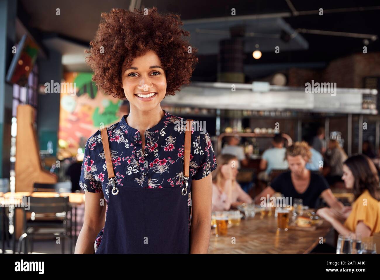 Porträt der Kellnerin, die in der geschäftigen Bar Restaurant Stockfoto