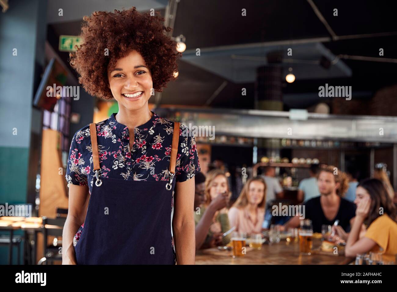 Porträt der Kellnerin, die in der geschäftigen Bar Restaurant Stockfoto