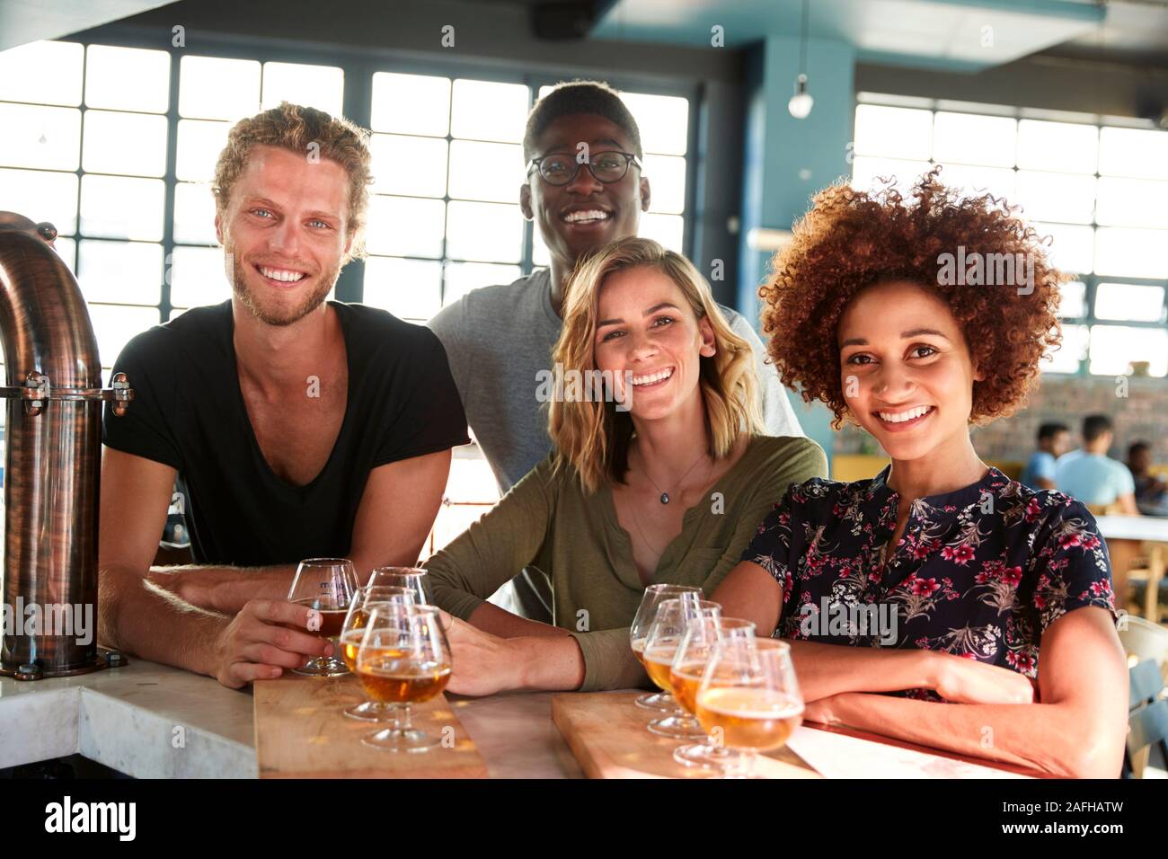 Porträt der Gruppe der Freunde Bierprobe Sitzen an der Bar Stockfoto