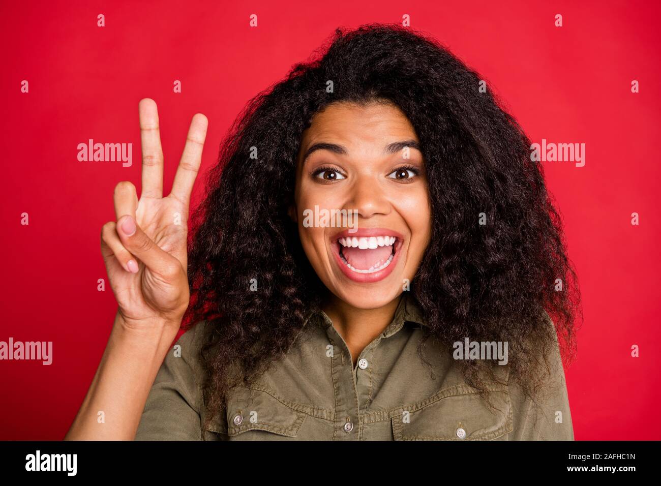 Cloe bis Portrait von fröhlichen positive niedlich hübsche süsse Art Freundin lächelnd toothily Ausdruck von Emotionen auf Gesicht zeigt v-Zeichen isoliert lebendige Stockfoto