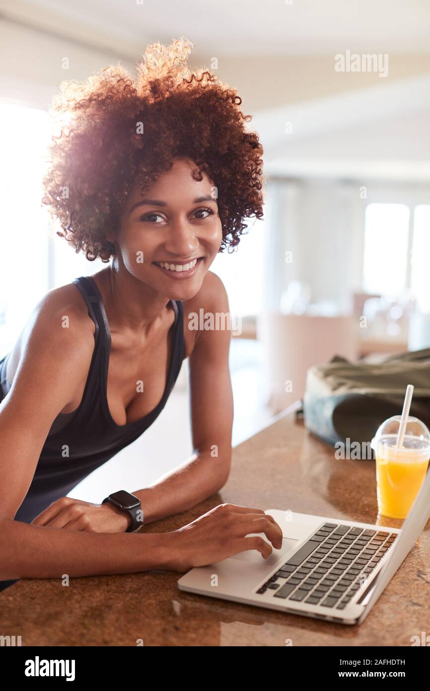 Tausendjährige afrikanische amerikanische Frau Kontrolle fitness Daten auf Notebook lächelnd in die Kamera, vertikal Stockfoto