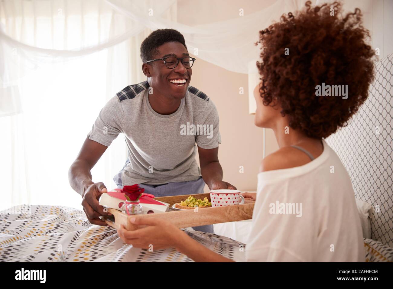 Tausendjährigen afrikanischen amerikanischen Paar feiern, Mann seinen Partner, Frühstück im Bett, in der Nähe Stockfoto
