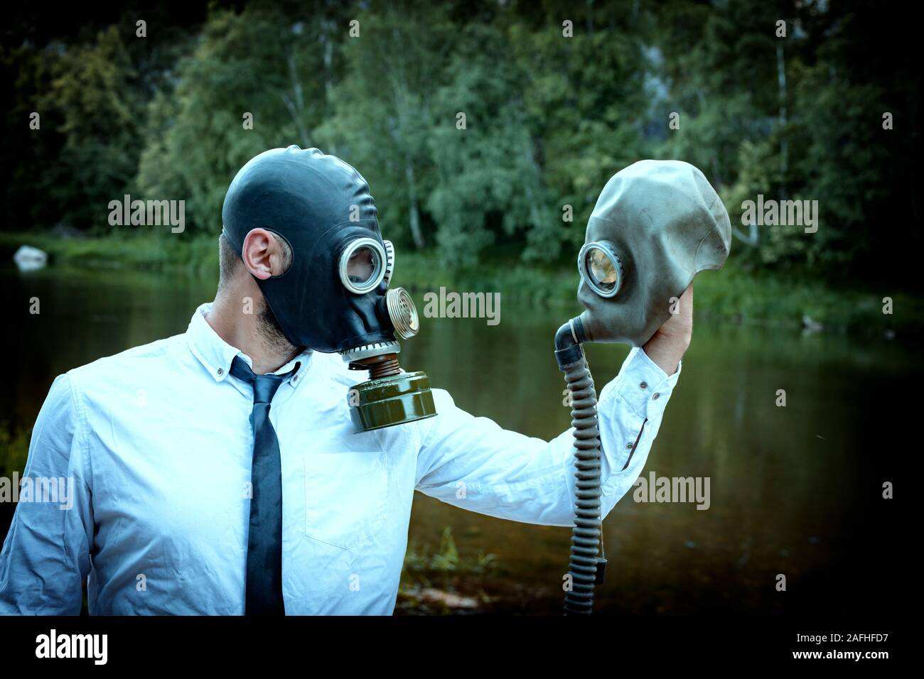 Mann in der Atemschutzmaske und weißes Hemd schaut leer, Gasmaske, bedauert, verlorenen Partner. Straffende und Vignette in Foto Stockfoto