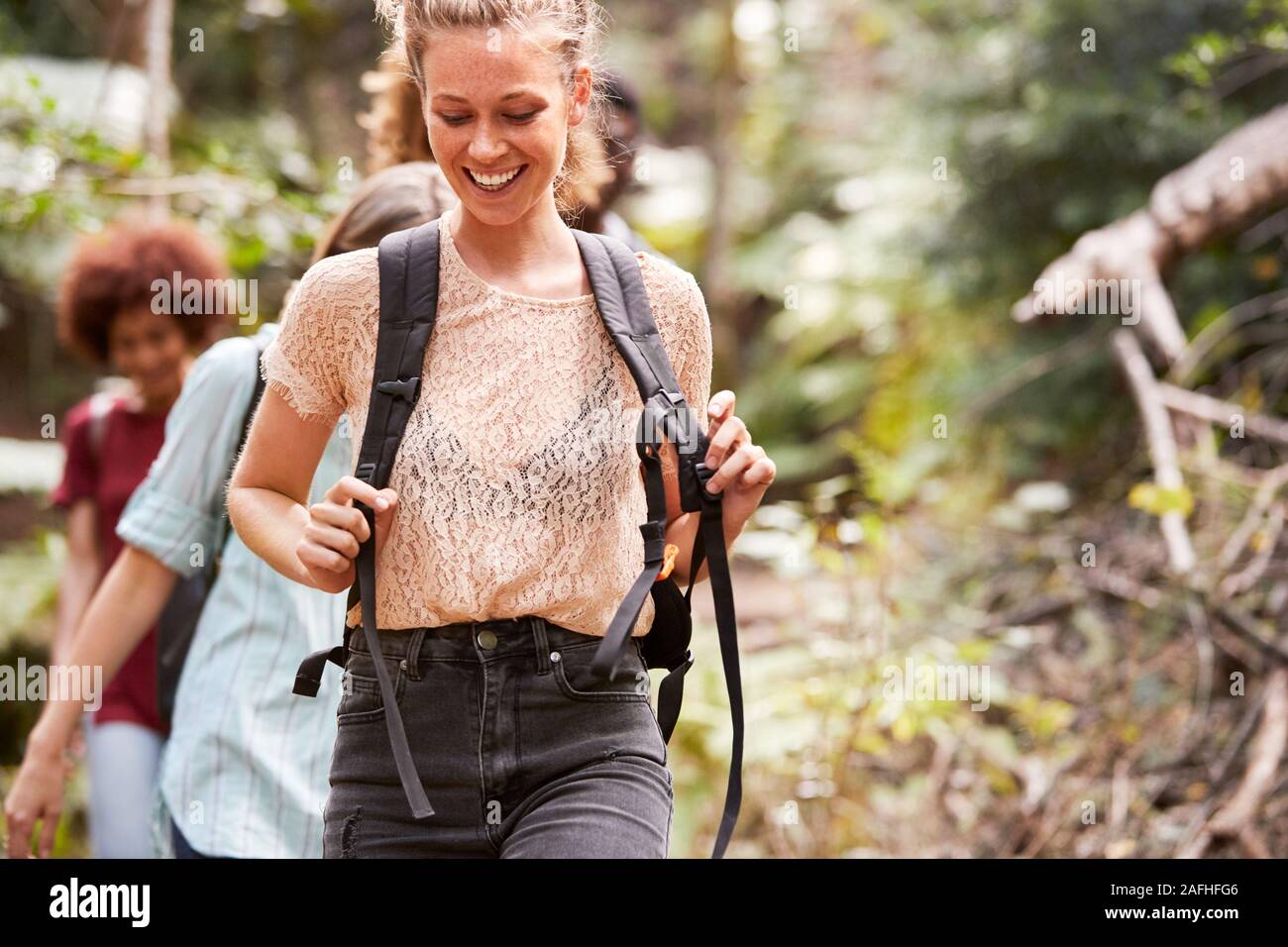 Tausendjährige weiße Frau wandern auf einem Waldweg mit Freunden, Nahaufnahme, Ansicht von vorne Stockfoto