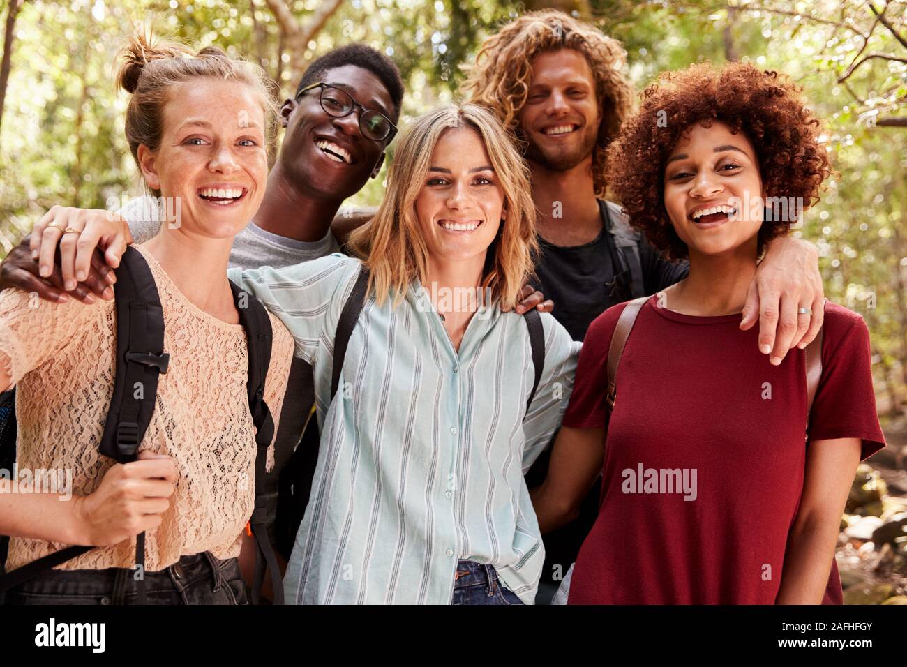 Fünf tausendjährigen Freunde auf eine Wanderung im Wald lächelnd in die Kamera, an der Hüfte oben, oben schließen Stockfoto