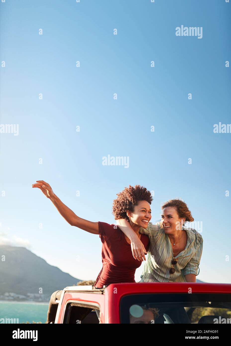 Zwei tausendjährige weibliche Freunde auf einem Road Trip, der in der Rückseite eines oben offenen Auto, Nahaufnahme Stockfoto