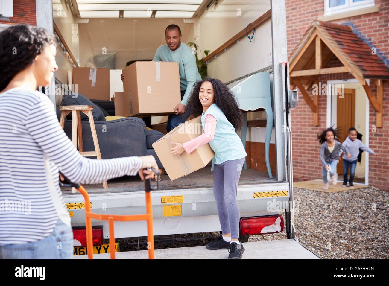 Familie Entladen Möbel aus Ausbau Lkw in neue Home Stockfoto