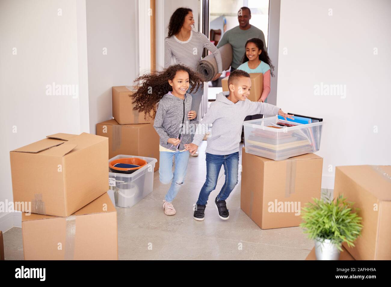 Lächelnd Familie Kisten in die neue Heimat am Umzugstag Stockfoto