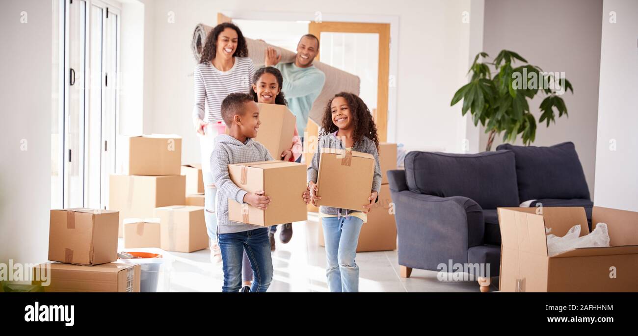 Lächelnd Familie Kisten in die neue Heimat am Umzugstag Stockfoto