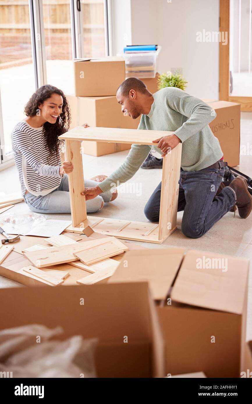 Paar im neuen Haus am Umzugstag zusammen, Selbstmontage Möbel Stockfoto