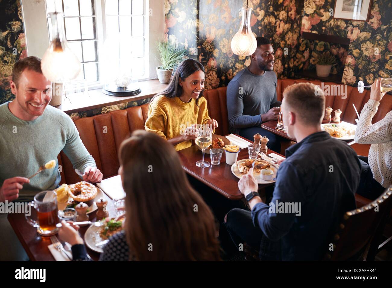 Gruppe von Menschen Essen im Restaurant des geschäftigen traditioneller englischer Pub. Stockfoto