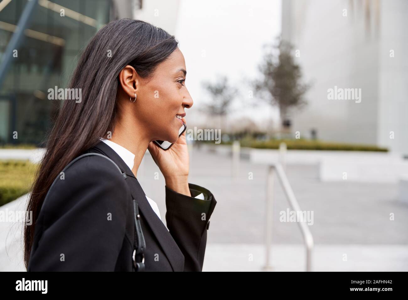 Geschäftsfrau Pendeln zur Arbeit Gespräch am Handy außerhalb Modernes Bürogebäude Stockfoto