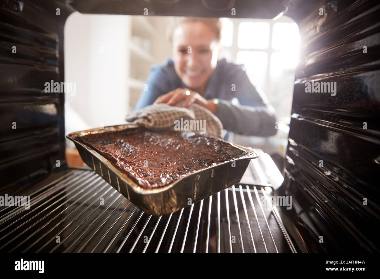 Betrachten aus dem Inneren Ofen als Frau brennt Abendessen Stockfoto