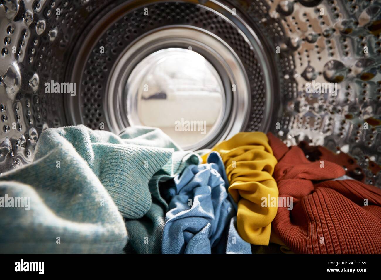 Blick aus dem Inneren Waschmaschine gefüllt mit Wäsche suchen Stockfoto
