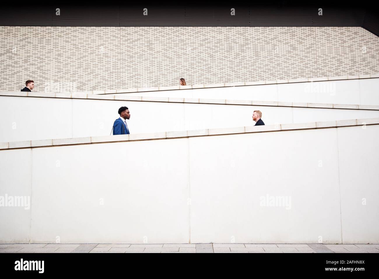 Grafik Schuß von Pendlern zu Fuß zur Arbeit entlang Beton Gehweg außerhalb von Gebäude Stockfoto