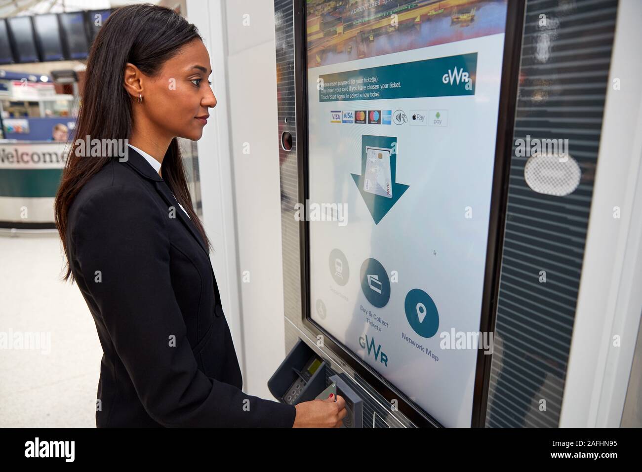 Geschäftsfrau Pendeln zur Arbeit kaufen Zug Ticket von Self-service-Maschine Stockfoto