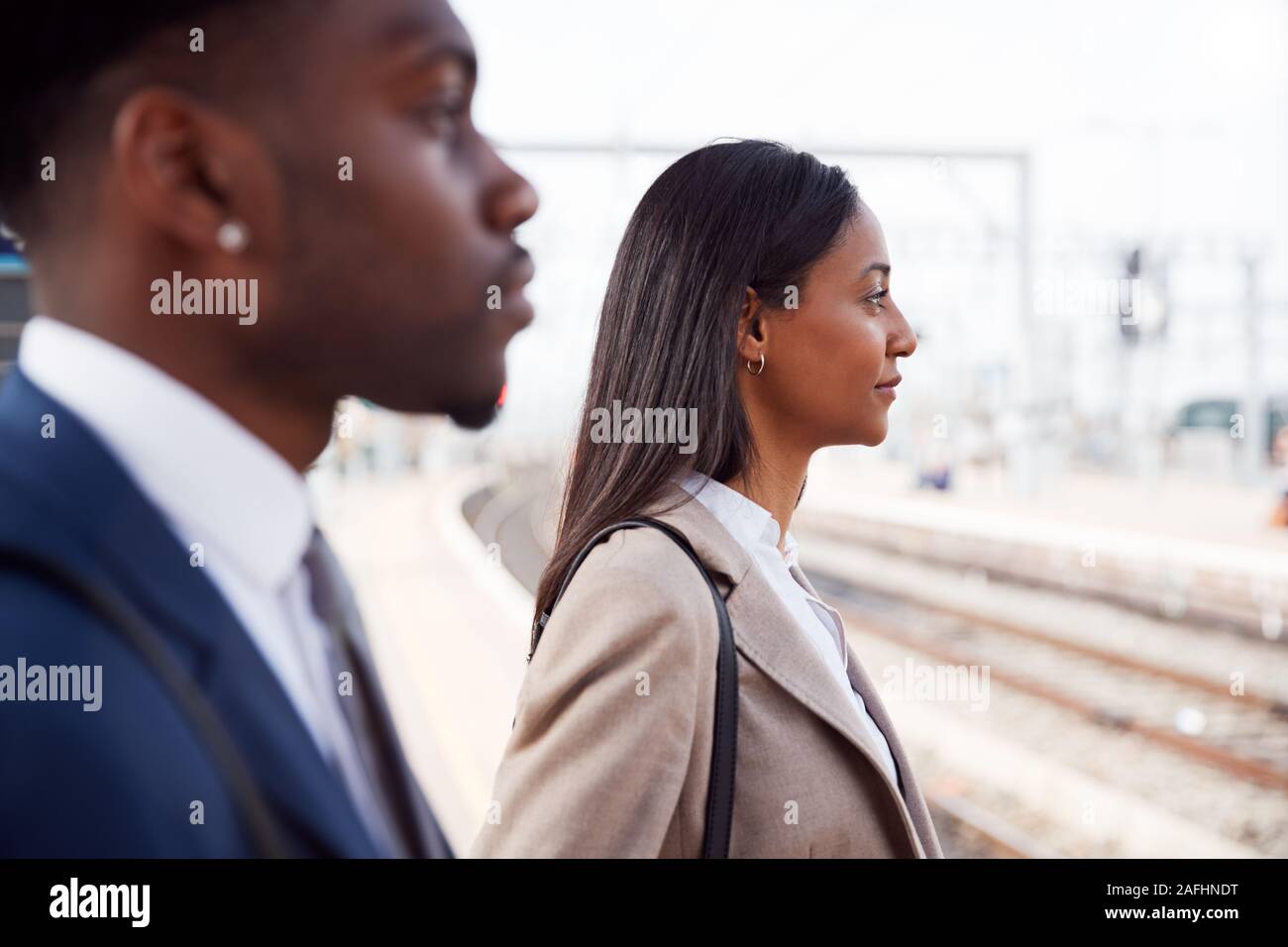 Kaufmann und Kauffrau Pendeln zur Arbeit am Bahnsteig warten auf Zug Stockfoto