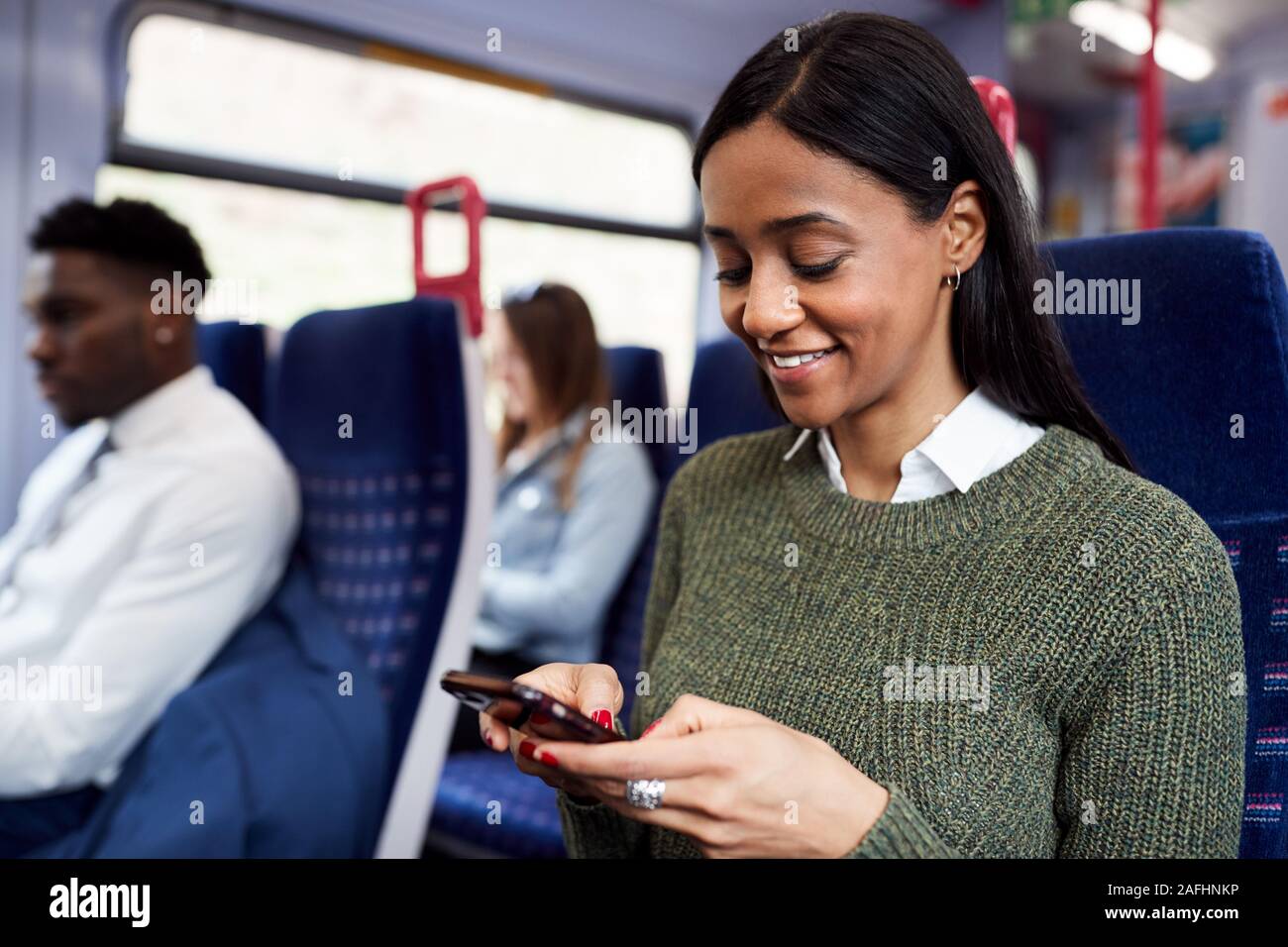 Weibliche Passagier sitzt im Zug am Handy suchen Stockfoto