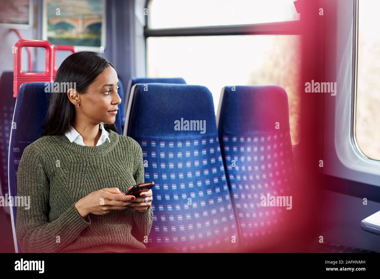 Weibliche Passagier sitzt im Zug am Handy suchen Stockfoto