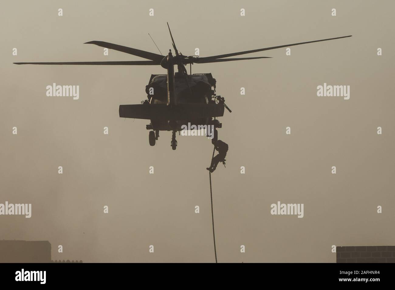 Militärischen Kampf und Krieg mit dem Hubschrauber in das Chaos und Zerstörung zu fliegen. Soldaten aus Seil auf den Boden von Chopper aussetzen. Militärisches Konzept Stockfoto