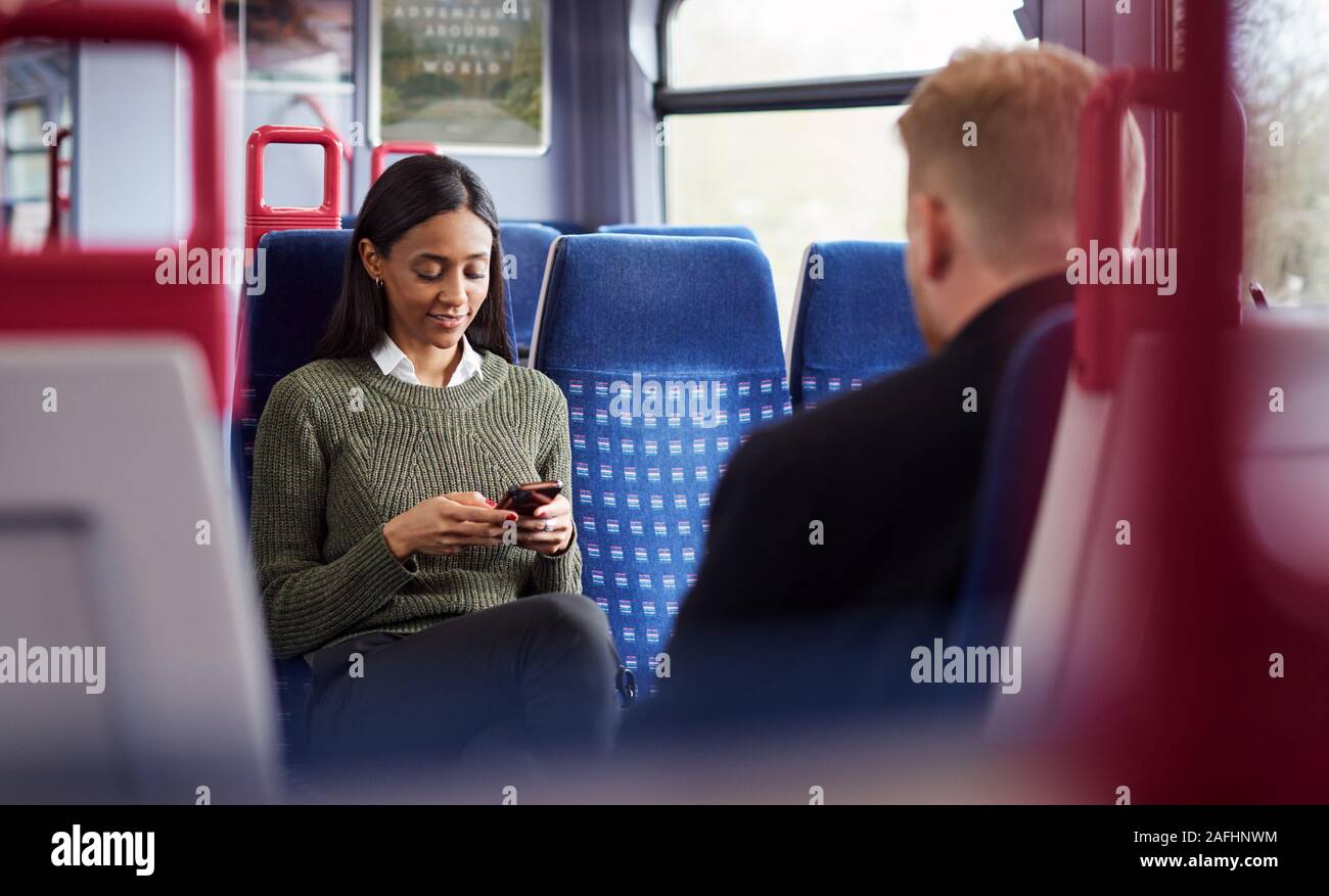 Weibliche Passagier sitzt im Zug am Handy suchen Stockfoto