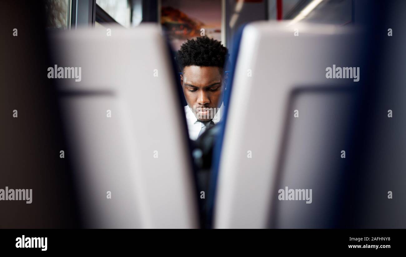 Geschäftsmann sitzt in dem Zug pendeln zur Arbeit gesehen zwischen zwei Sitze Stockfoto