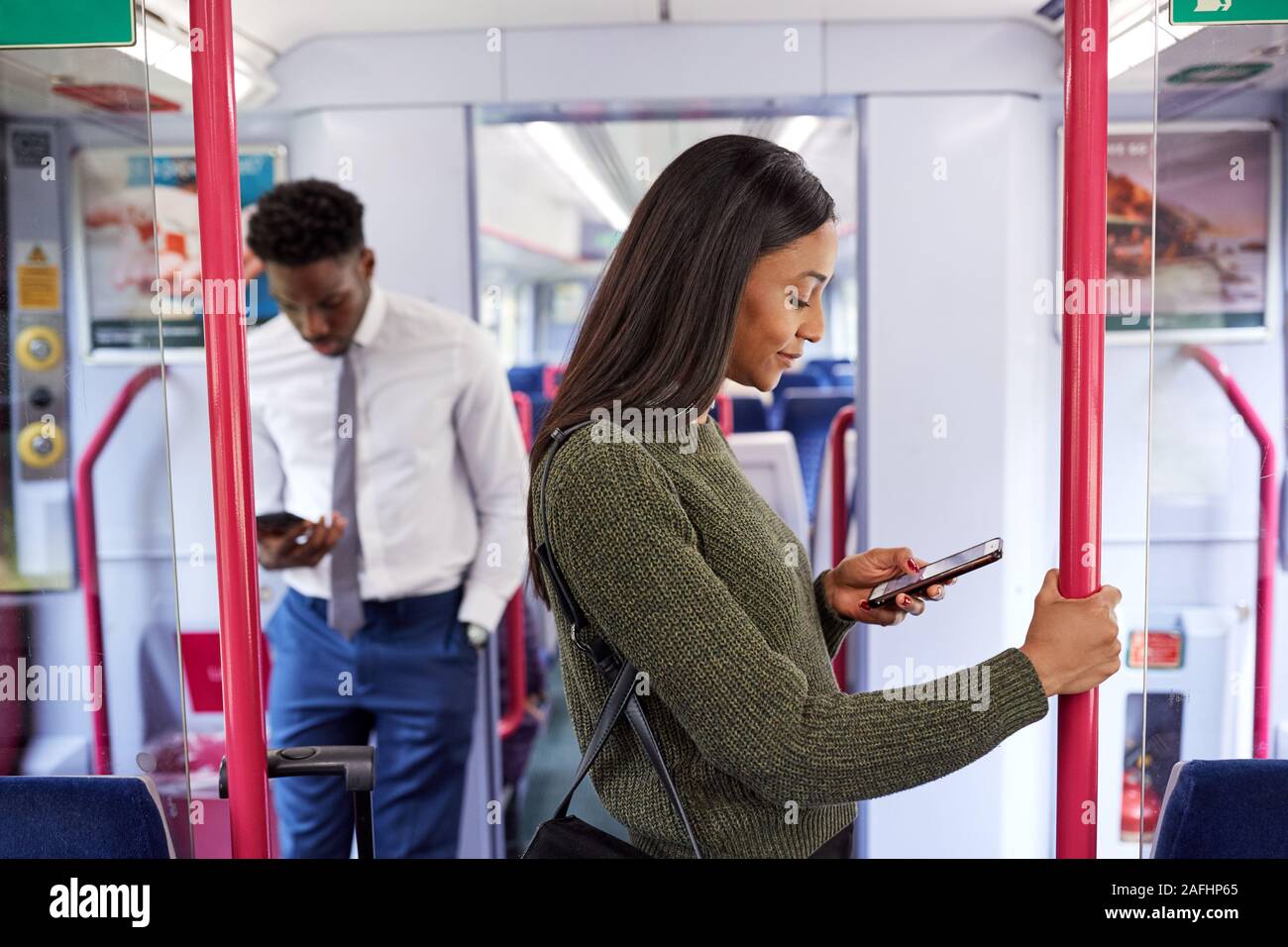 Business Passagiere im Zug pendeln auf Mobiltelefone zu arbeiten Stockfoto