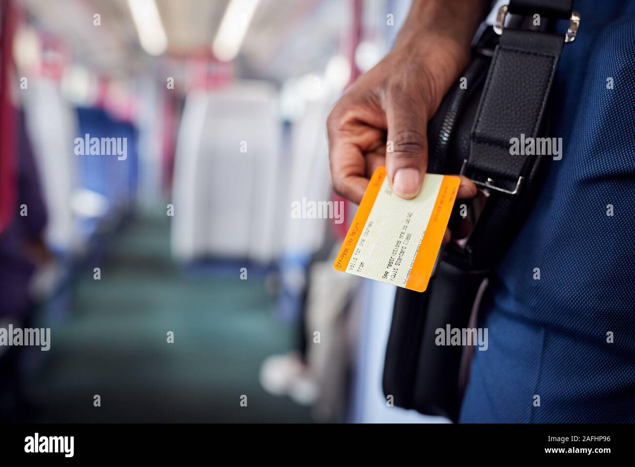 Nahaufnahme von Geschäftsmann in Zug pendeln zur Arbeit Holding Ticket Stockfoto