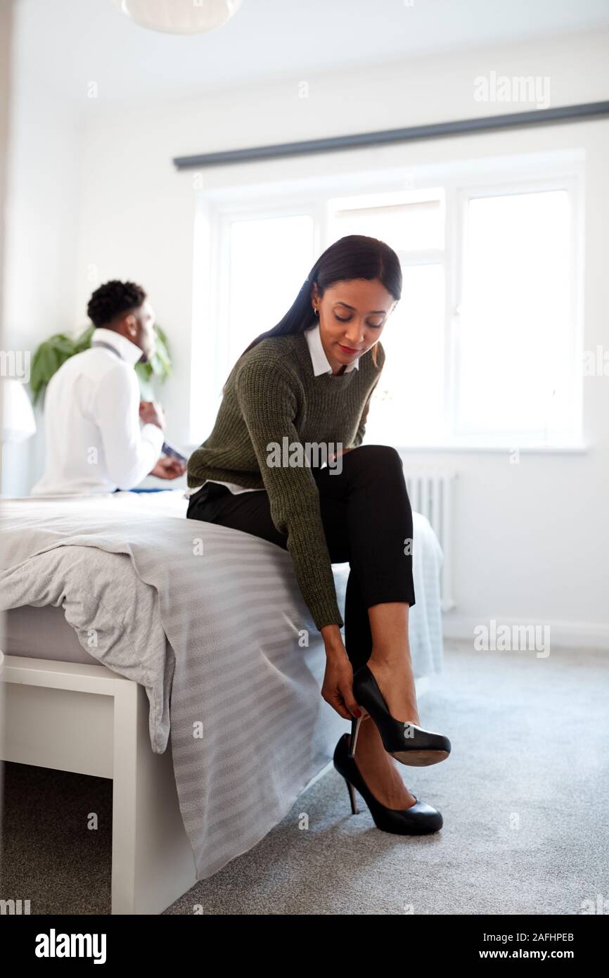 Business Paar im Schlafzimmer Bereit für Arbeit Geschäftsfrau zu Hause Setzen auf Schuhe Stockfoto