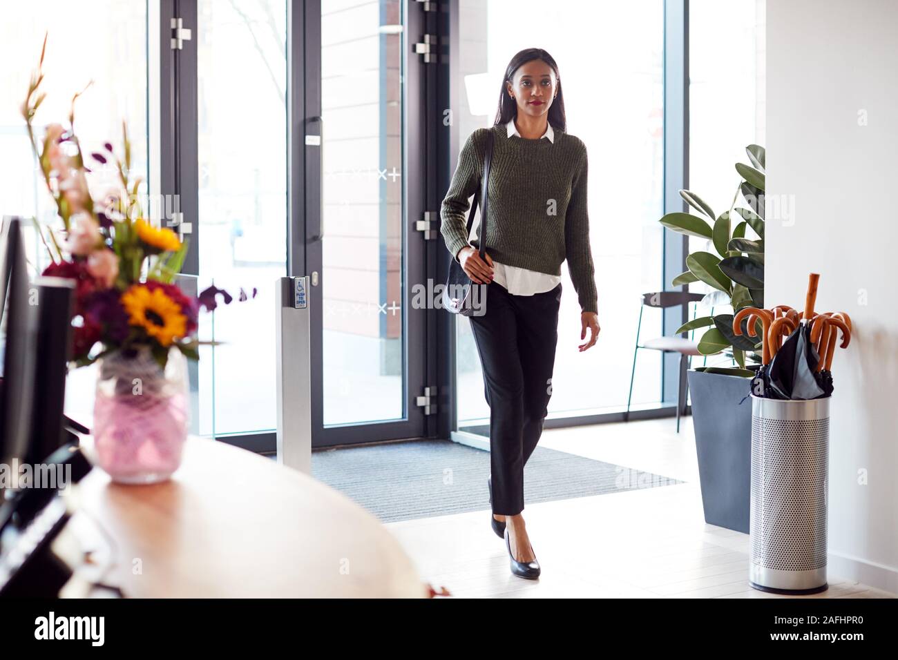 Geschäftsfrau anreisen, für die Arbeit im Büro zu Fuß durch die Tür Stockfoto