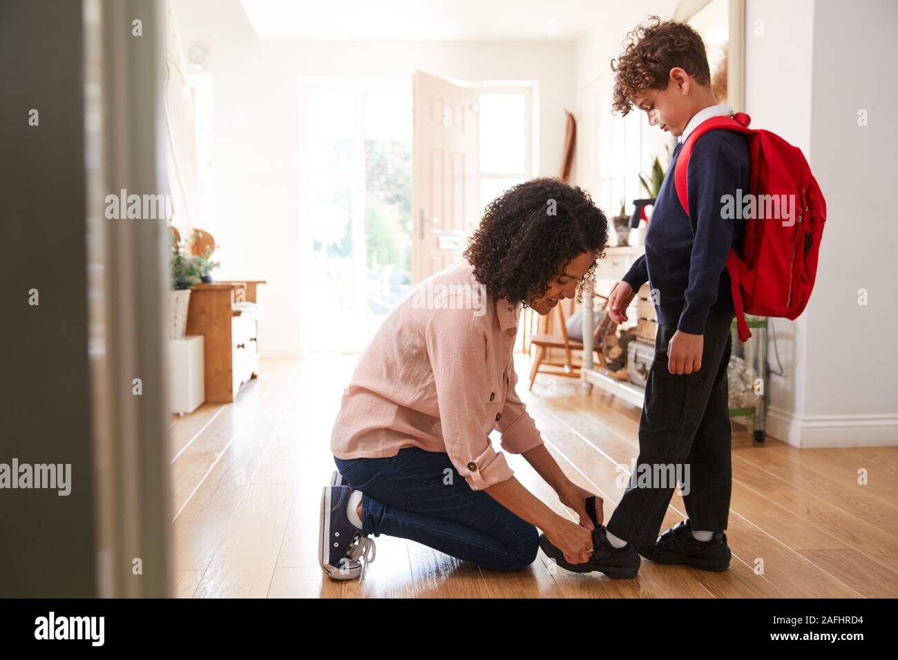 Alleinerziehende Mutter zu Hause, Sohn tragen einheitliche Bereit für den ersten Tag der Schule Stockfoto