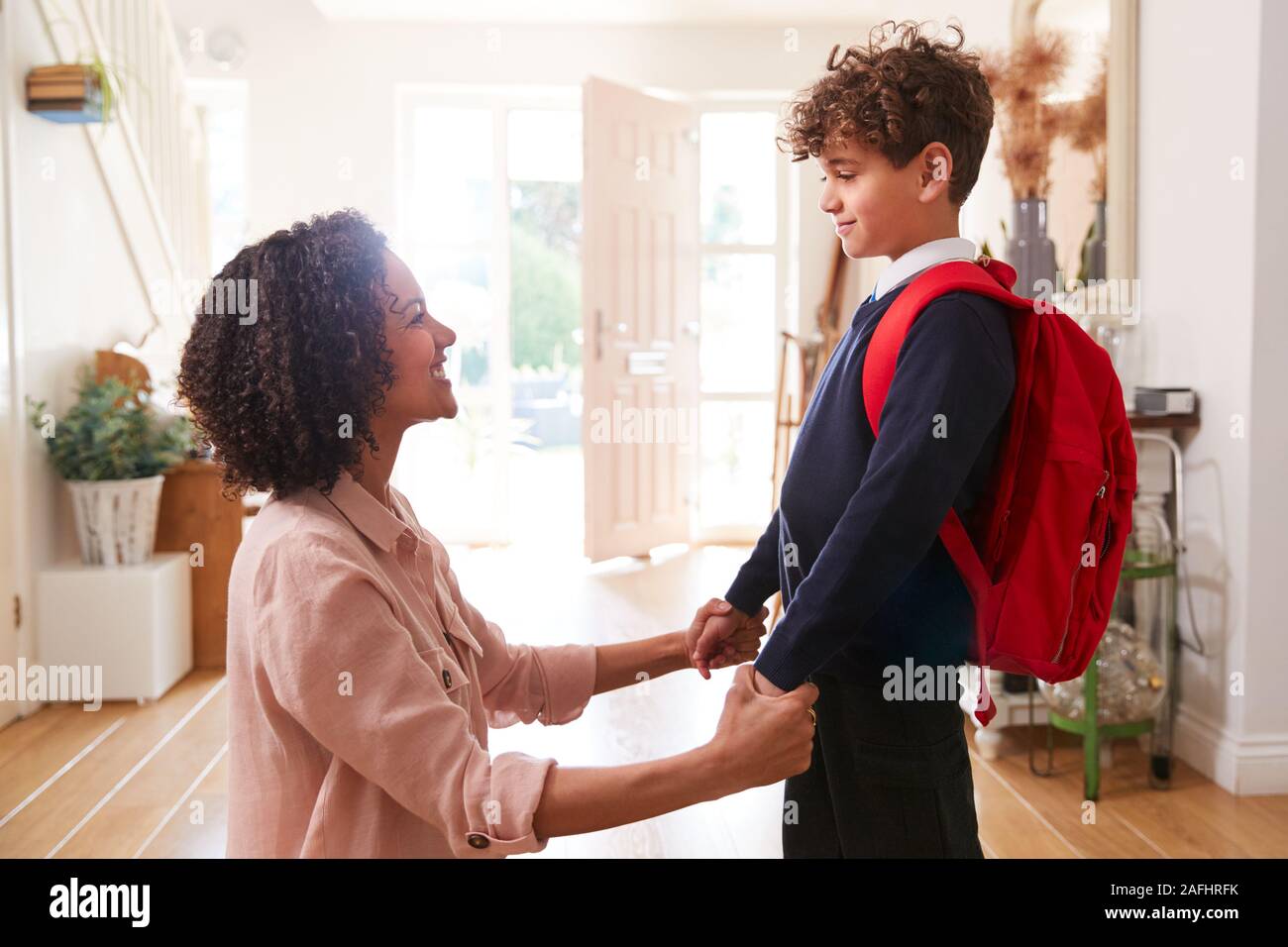 Alleinerziehende Mutter zu Hause, Sohn tragen einheitliche Bereit für den ersten Tag der Schule Stockfoto