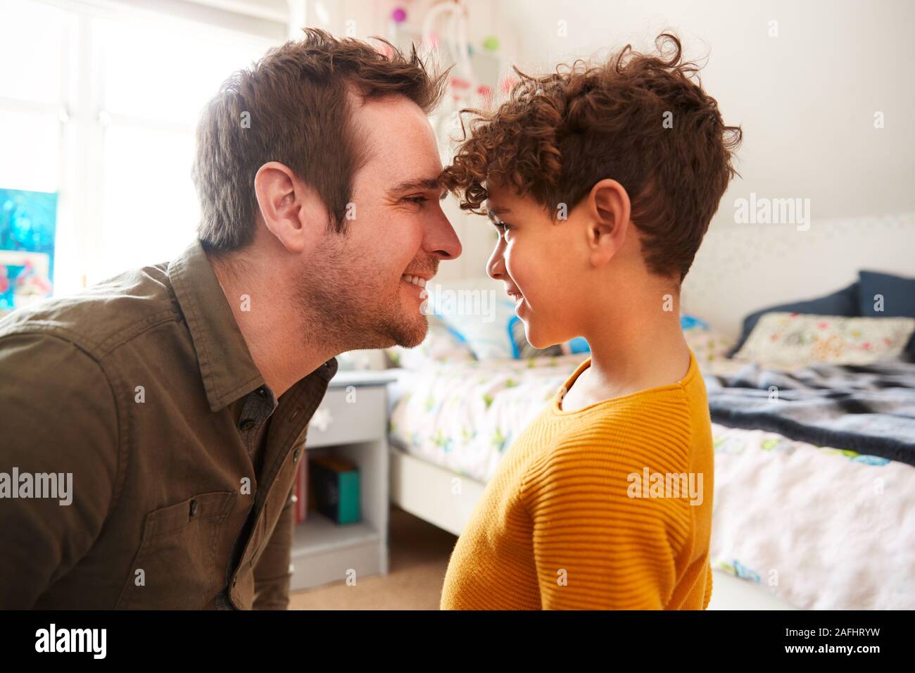 Einzelnen Vater Kopf an Kopf zu Hause mit Sohn im Schlafzimmer zu Hause Stockfoto