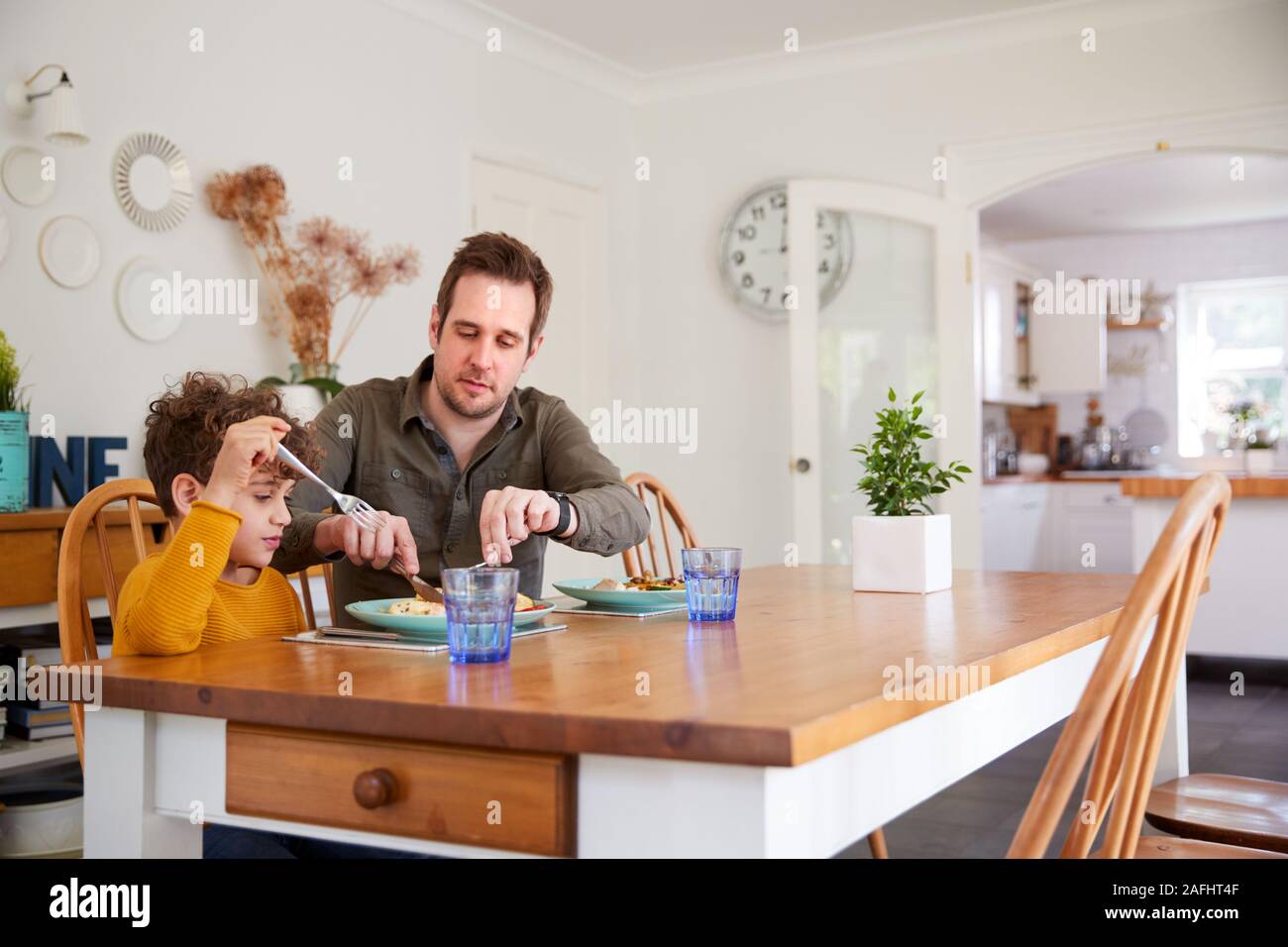 Einzelnen Vater sitzt am Tisch essen Mahlzeit mit Sohn in der Küche zu Hause. Stockfoto