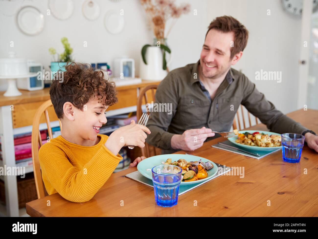 Einzelnen Vater sitzt am Tisch essen Mahlzeit mit Sohn in der Küche zu Hause. Stockfoto