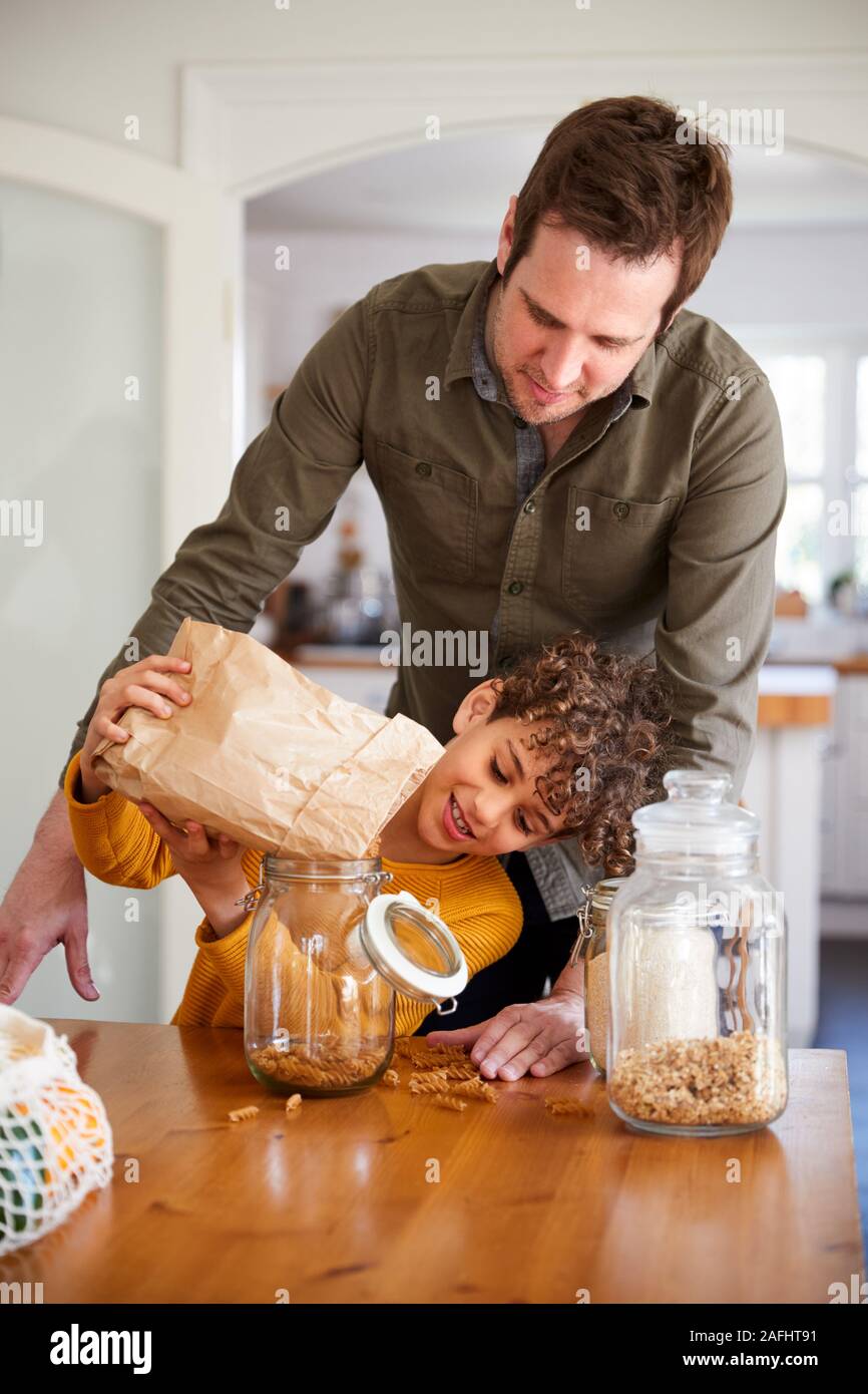 Vater hilft Sohn zum Nachfüllen für Lebensmittel zu Hause mit Null Verpackungsmüll Stockfoto